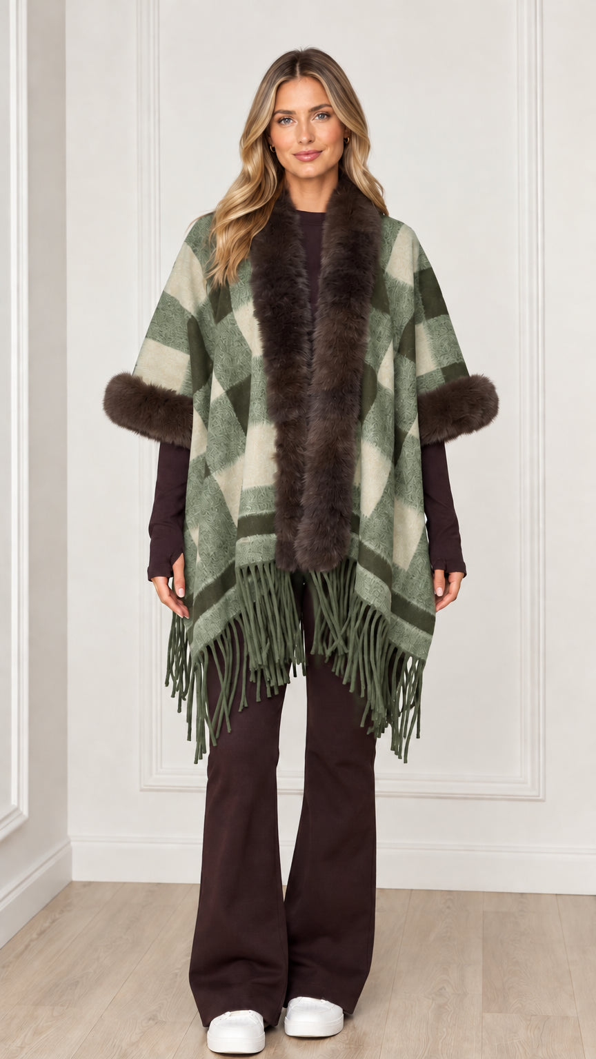 Woman wearing sage green plaid poncho wrap with faux fur collar and hem tassels