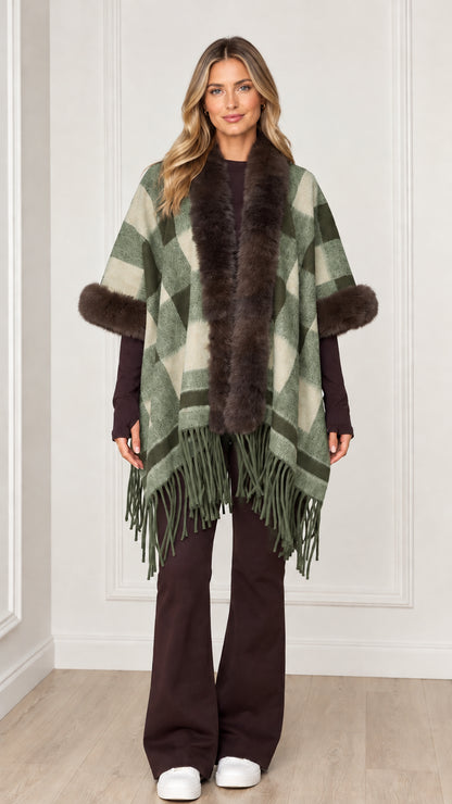 Woman wearing sage green plaid poncho wrap with faux fur collar and hem tassels