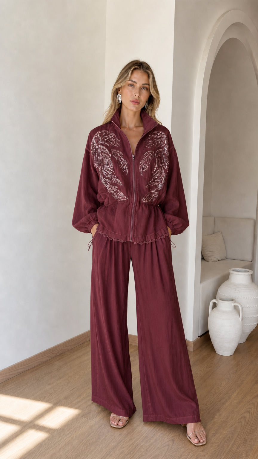 Front full view of woman wearing burgundy wine embroidered zip jacket and wide-leg pants set