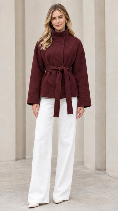 Front view of model wearing burgundy stand collar belted short coat