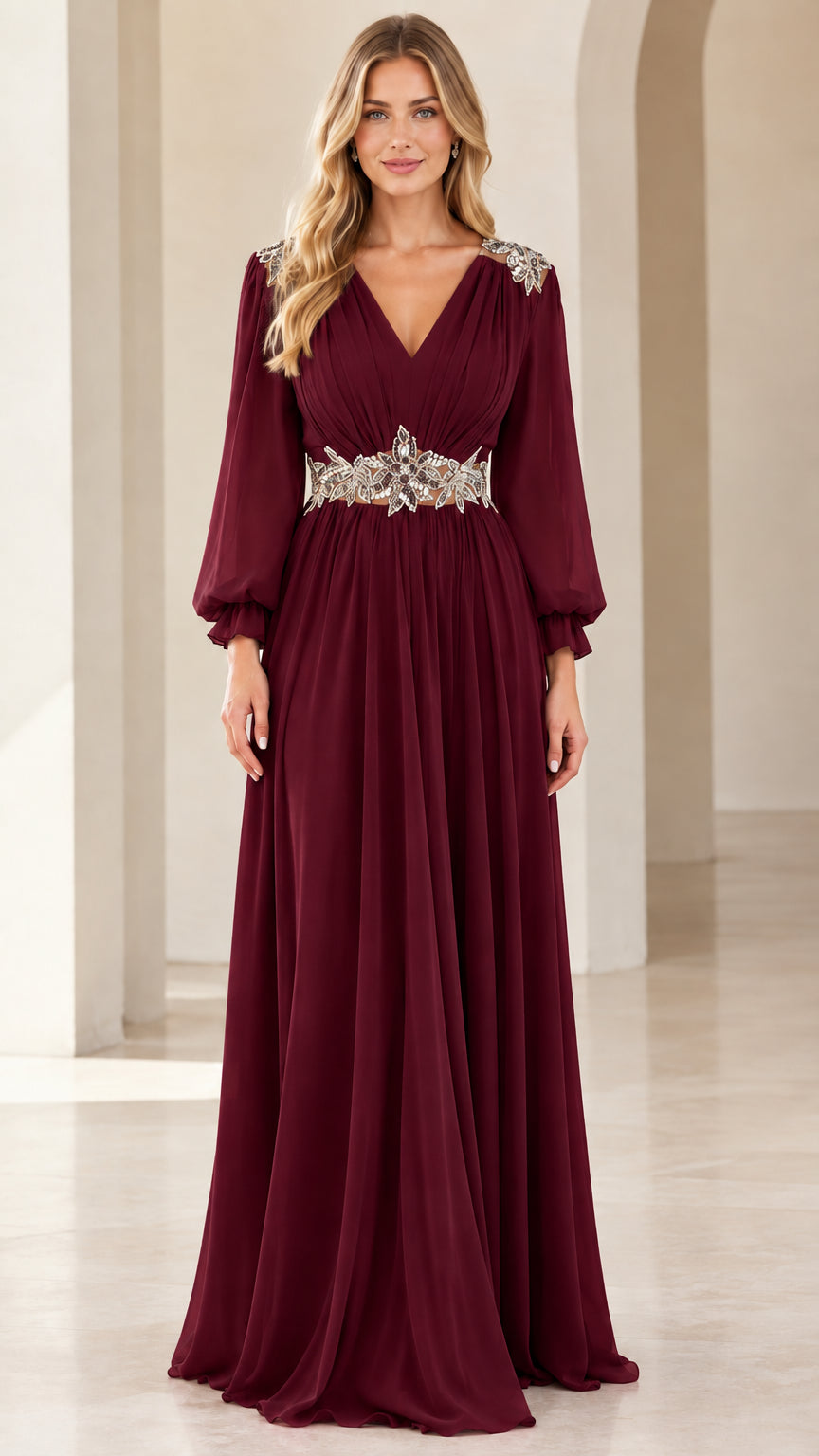 Front view of woman wearing burgundy long-sleeve chiffon evening gown with crystal waistband