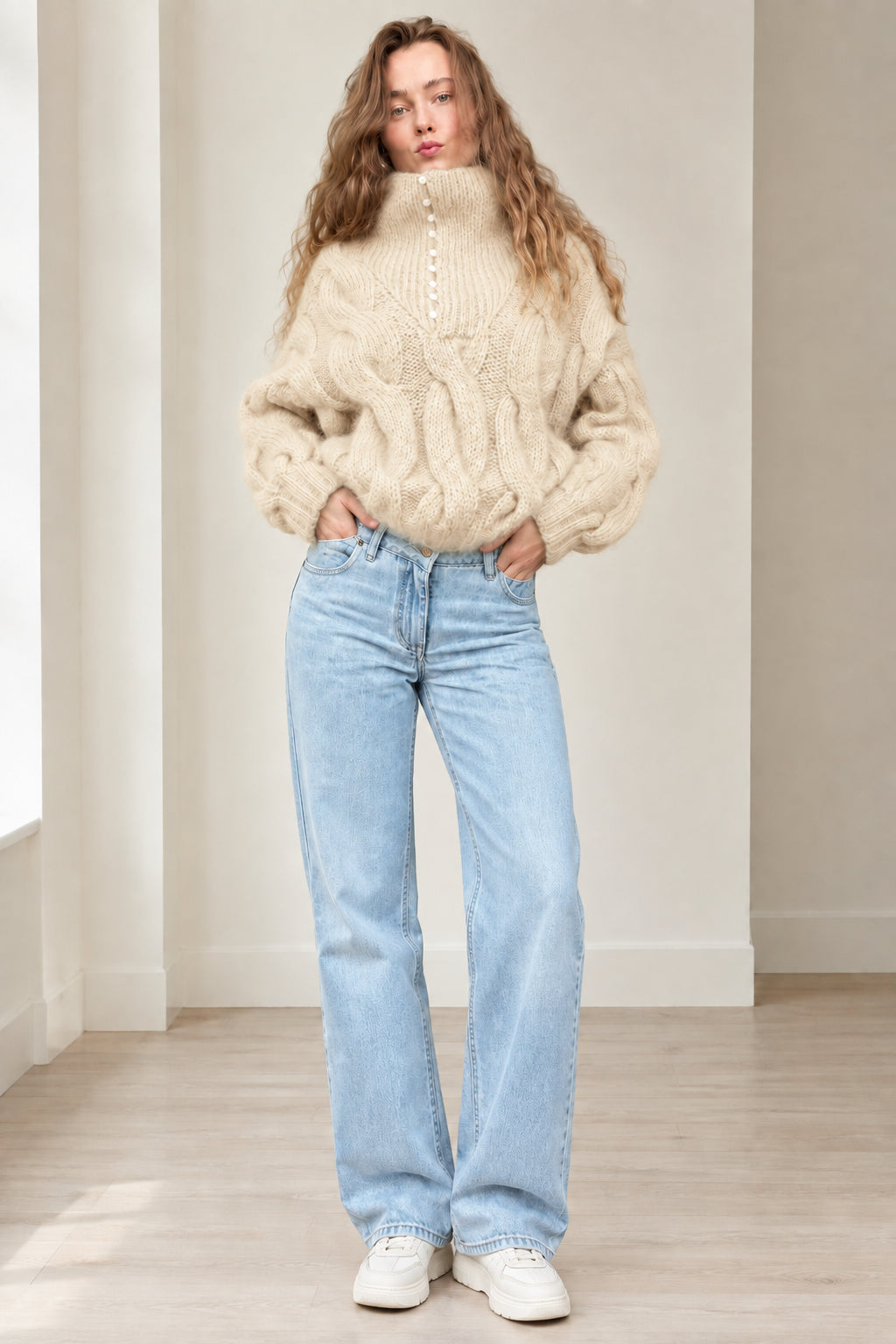Model wearing beige cream chunky cable knit button high neck sweater