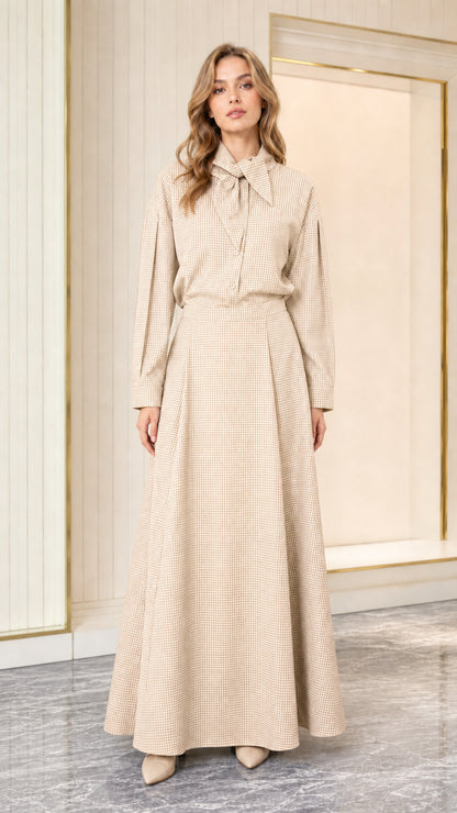 Model wearing beige houndstooth long sleeve tie-neck maxi dress