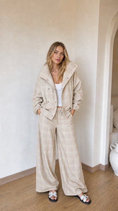 Model wearing beige cream plaid high-collar jacket and wide-leg matching set