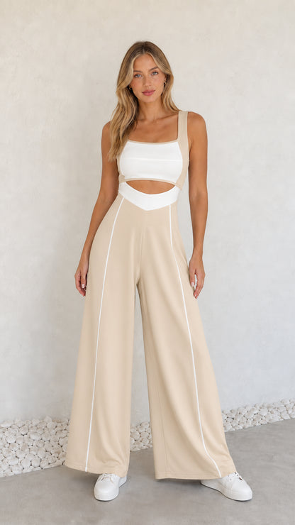Model wearing beige colorblock cutout wide-leg jumpsuit with white piping