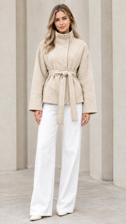 Front view of model wearing beige stand collar belted short coat